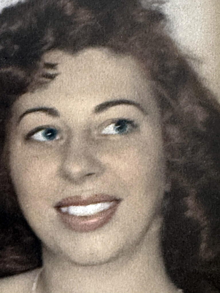 A young photo of Joan, a woman smiling brightly.