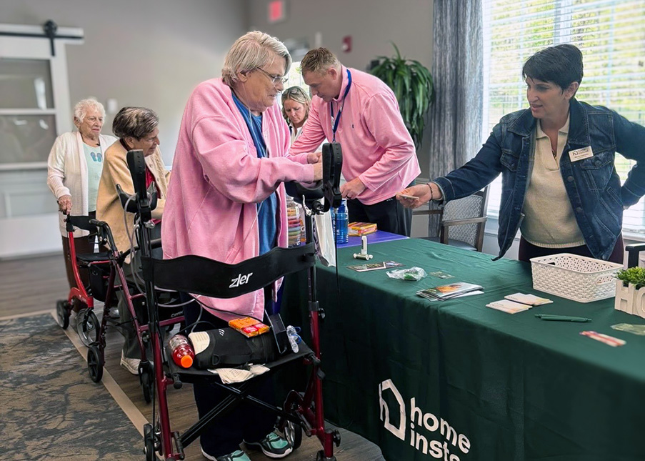 Seniors visit a display table at a wellness event in the community.