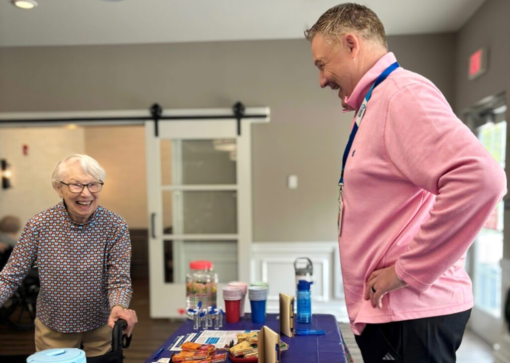 A senior woman browses the items on a display table at a wellness event in the community.
