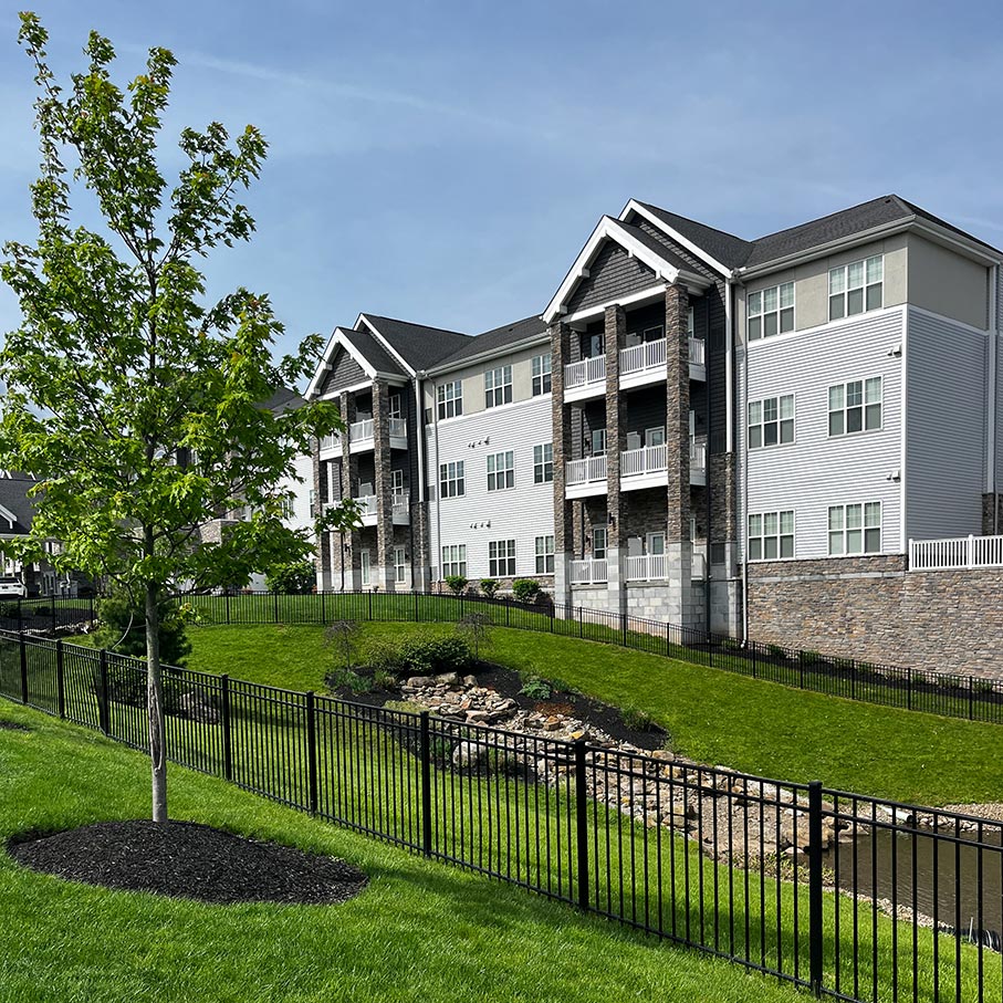 The exterior of Vitalia Rockside, trees and an expanse of green grass in the foreground.